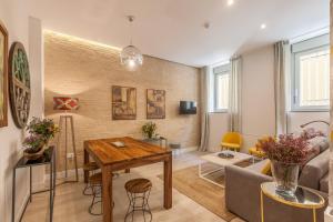 a living room with a table and a couch at Apartamentos RG Suites Jardines de Murillo in Seville