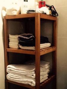 uma prateleira de madeira com toalhas e toalhas na casa de banho em Le Cinq em Vilamoura