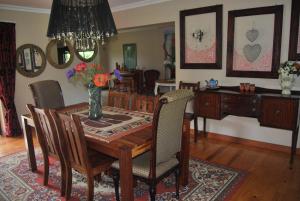 a dining room with a wooden table and chairs at 15 Witpeer Street Guesthouse in George