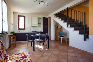 a kitchen and living room with a table and a staircase at La Fonte degli Angeli Apartments in Suvereto