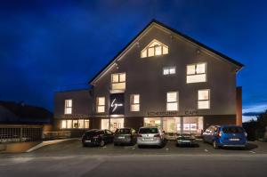 a building with cars parked in a parking lot at Hotel Restaurant Sailer in Seewalchen
