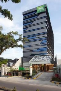 um edifício alto com um sinal em cima em ibis Styles Medan Pattimura em Medan