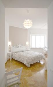 a white bedroom with a bed and a chair at Villa Mori in Levanto