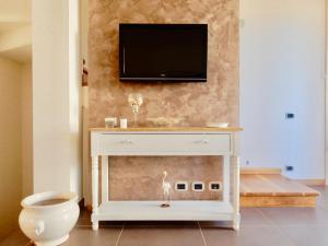 uma cómoda branca com uma televisão na parede em Villa Mare em Lido di Camaiore
