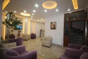 a waiting room with purple chairs and stairs at Gulistan Hotel in Zara
