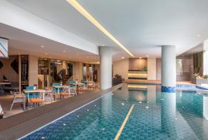 una piscina dell'hotel con tavoli e sedie di ibis Styles Medan Pattimura a Medan