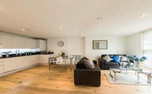 ein Wohnzimmer mit Sofa und Tisch in der Unterkunft Finchley Central - Luxury 2 bed ground floor apartment in Hendon