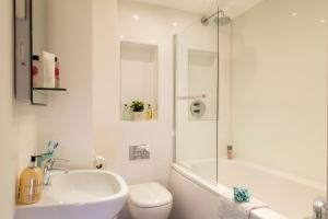 ein weißes Badezimmer mit einem Waschbecken, einem WC und einer Dusche in der Unterkunft Finchley Central - Luxury 2 bed ground floor apartment in Hendon