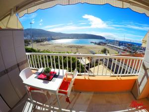 a balcony with a table and chairs and a view of a beach at Edificio Arco in Los Cristianos