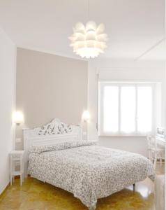 a white bedroom with a bed and a chandelier at Villa Mori in Levanto