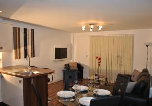 a living room with a table and chairs and a kitchen at Dreamhouse Apartments Manchester City West in Manchester