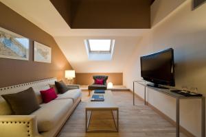 a living room with a couch and a flat screen tv at Vincci Selección Posada del Patio in Málaga
