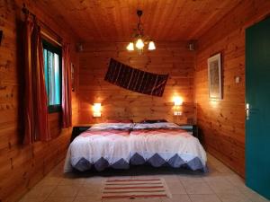 a bedroom with a bed in a wooden cabin at Chen Ba'Galil in Kahal