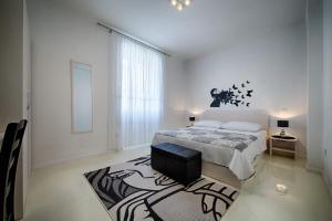 维斯Apartment Jure的一间白色卧室,配有床和地毯