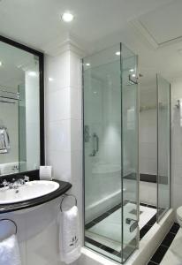 La salle de bains est pourvue d'une douche en verre et d'un lavabo. dans l'établissement 41, à Londres