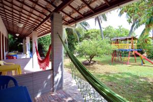 a hammock on the side of a house with a playground at Hotel Pousada Ipitanga IV in Lauro de Freitas +115 photos