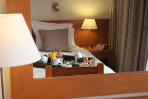 Postel nebo postele na pokoji v ubytování Achillion Hotel