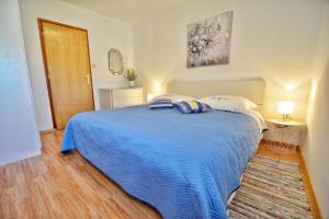 1 dormitorio con 1 cama azul en una habitación en Apartment Fjaka en Sali