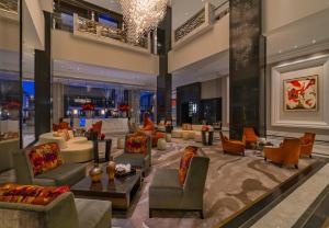 a hotel lobby with couches and chairs and a chandelier at The Post Oak Hotel in Houston