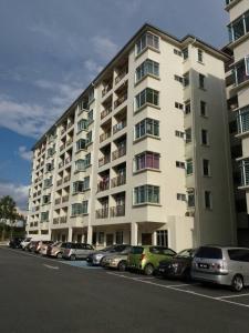 um grande edifício de apartamentos com carros estacionados em frente em Ijanina Homestay em Bandar Puncak Alam
