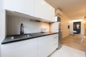 a kitchen with a sink and a refrigerator at F2 chambre en duplex (calme) plein centre ville 1 min de la plage in Saint-Raphaël