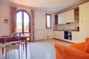 uma cozinha com uma mesa e uma sala de jantar em La Fonte degli Angeli Apartments em Suvereto