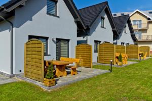 a house with a picnic table in the yard at Domki OAZA in Ostrowo