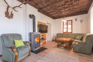 a living room with a fireplace and couches and a tv at Pension Rudolfshöhe in St. Wolfgang
