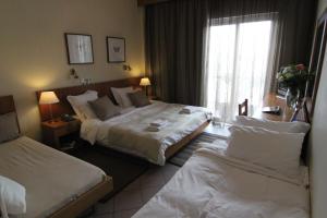 Postel nebo postele na pokoji v ubytování Achillion Hotel
