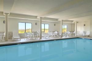 a large swimming pool with chairs and a table at Wingate By Wyndham - Warner Robins in Warner Robins