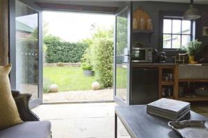 a kitchen with a sliding glass door to a garden at Elm Cottage Barn in Oatlands