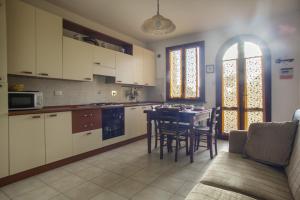 a kitchen with a table and chairs and a dining room at La Fonte degli Angeli Apartments in Suvereto