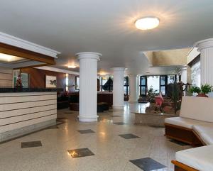 a living room with columns and a lobby with a couch at Hotel da Lea in Guarapari