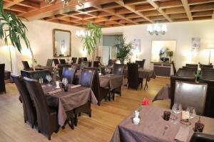 un restaurante con mesas y sillas en una habitación en Logis L'Ecu De France, en Mauriac