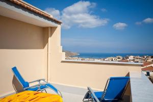 dwa niebieskie krzesła na balkonie z widokiem na ocean w obiekcie Le Case di Katy w mieście Castellammare del Golfo