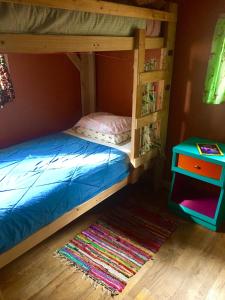 a bunk bed with a blue bedsheet and a table at The Wanderlust Hostel in Gunnison