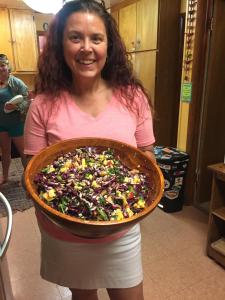 a woman is holding a large bowl of food at The Wanderlust Hostel in Gunnison