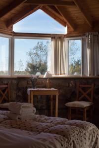 ein Schlafzimmer mit einem Bett und einem großen Fenster in der Unterkunft La Calandria Casa de Campo in Puerto Madryn