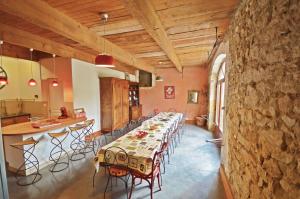 Un comedor largo con una mesa larga y sillas. en Mas du Fer à Cheval, en Lamotte-du-Rhône