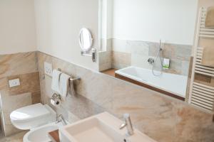 ein Badezimmer mit einem Waschbecken, einem WC und einem Spiegel in der Unterkunft Residence Gruberhof in Schenna