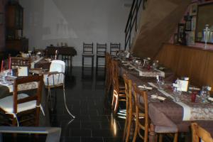 a restaurant with long tables and chairs and a piano at B&B Le Relais de Charlinette in Boignée