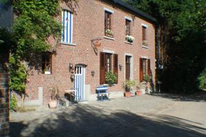 a brick building with a bench in front of it at B&B Le Relais de Charlinette in Boignée