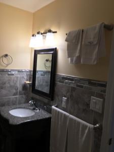 a bathroom with a sink and a mirror and towels at Sunparlor Motel in Leamington