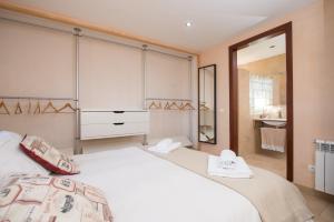 um quarto com uma grande cama branca e um espelho em Es Mitja Davall em Sencelles