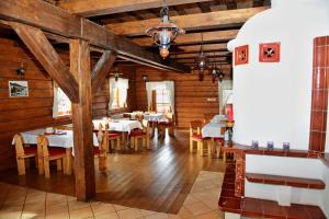 a dining room with tables and chairs and wooden walls at Penzión Schweintaal in Bravačov