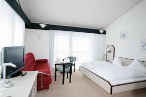 een hotelkamer met een bed en een rode stoel bij Hotel Abendroth in Chemnitz