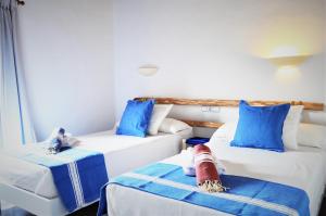 two beds in a room with blue and white at Siamoformentera Alessandra in Sant Francesc Xavier