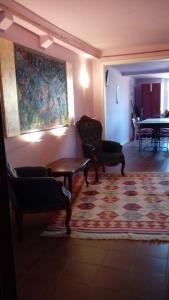ルッカにあるLiberi Mercanti - guest house affittacamereのリビングルーム(ソファ、椅子、ラグ付)