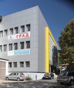 a building with cars parked in front of it at Konačište Grad B&B in Užice