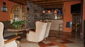 a bar with chairs and a table with a vase of flowers at Motel Za Grosik in Wałcz